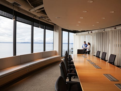 Two Executives In Conference Room Male and female Hispanic American executives in a conference in a brightly lit large conference room